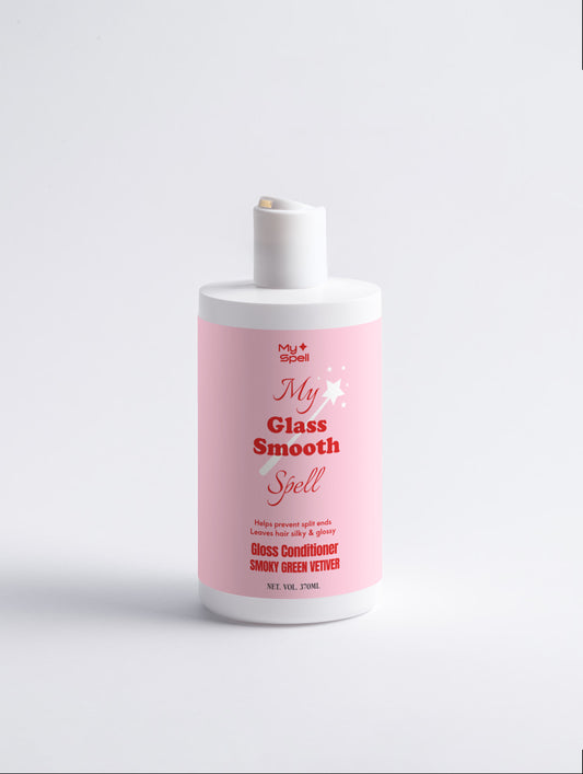 A bottle of My Spell, 'My Glass Smooth Spell' Gloss Conditioner, featuring a pink label and white bottle, set against a clean white background.